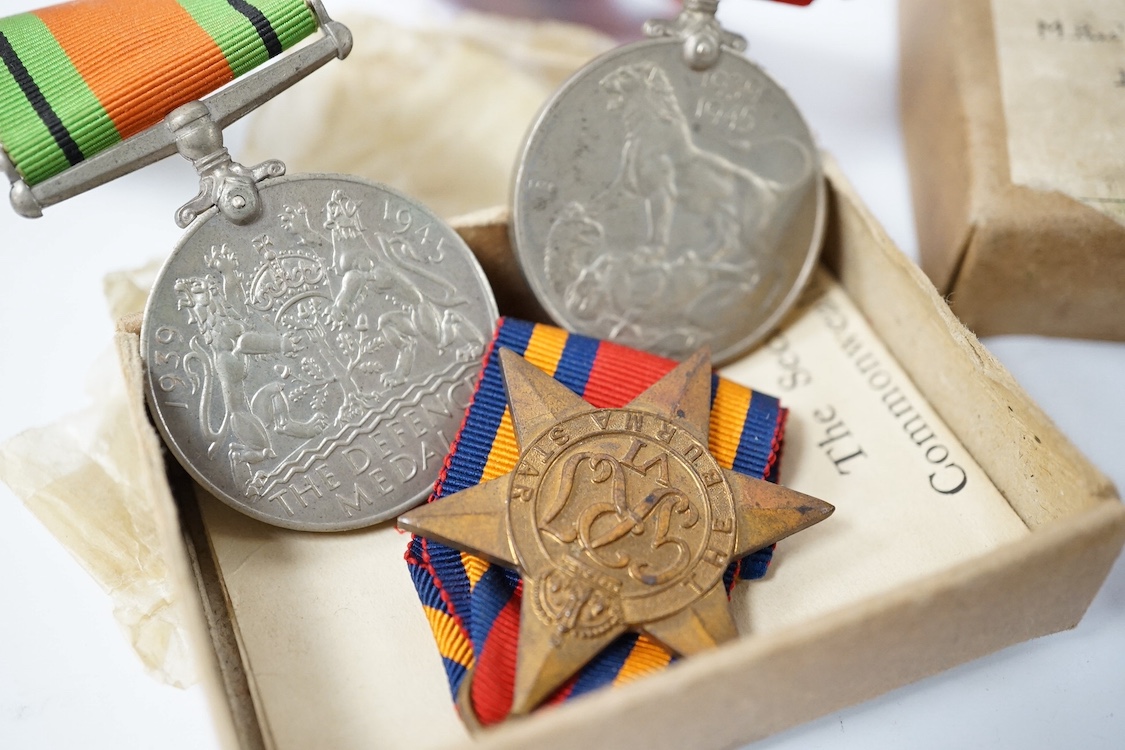 A WWII medal trio comprising a Burma Star, The Defence Medal and the 1939-1945 Medal, contained within their original card issue box, together with a Gurkha cap badge and a few other items. Condition - fair to good.